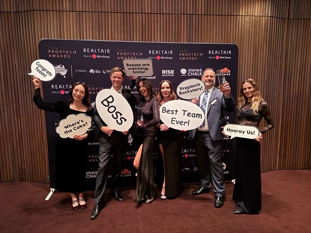 The Before You Buy team celebrating at the 2026 Proptech Awards, holding speech-bubble signs